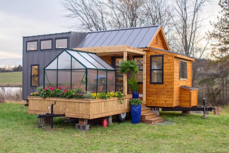 This gorgeous tiny home features a greenhouse and wooden pergola